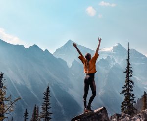 an excitement woman stands in the mountaints