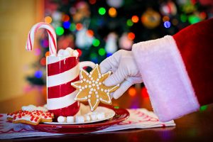 Santa's hand reaches in to take a cookie off a plate