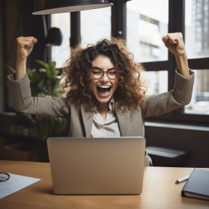 a businesswoman cheers at her computer