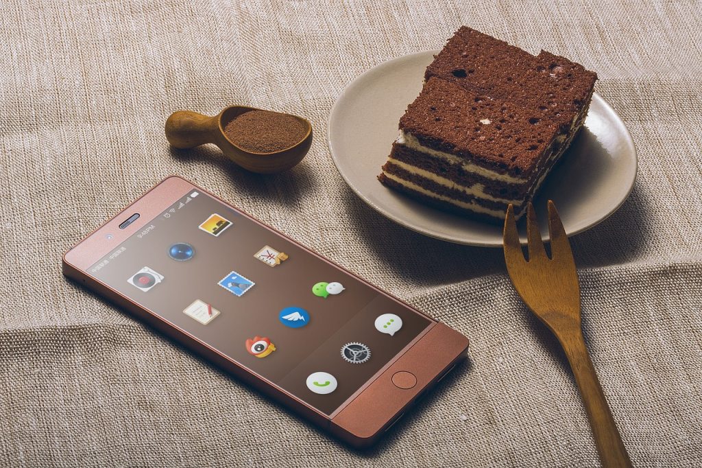 a cell phone next to a plate of tiramisu