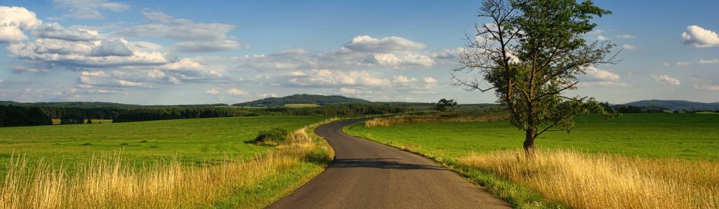 a winding road through green countryside