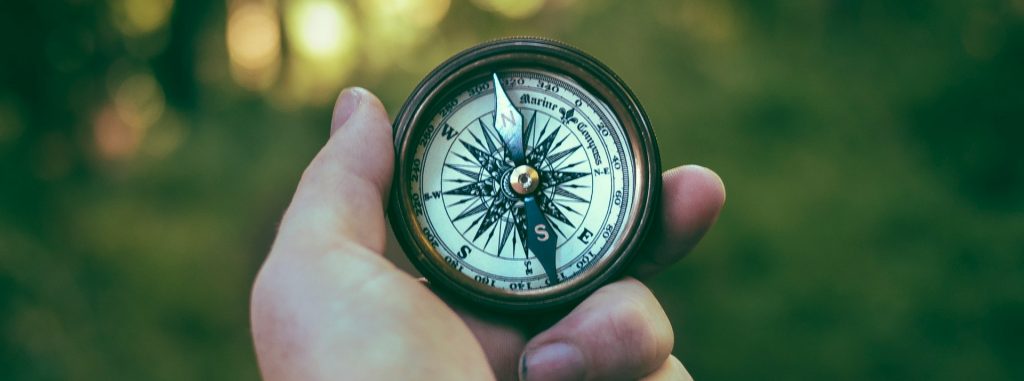 a hand holding a compass