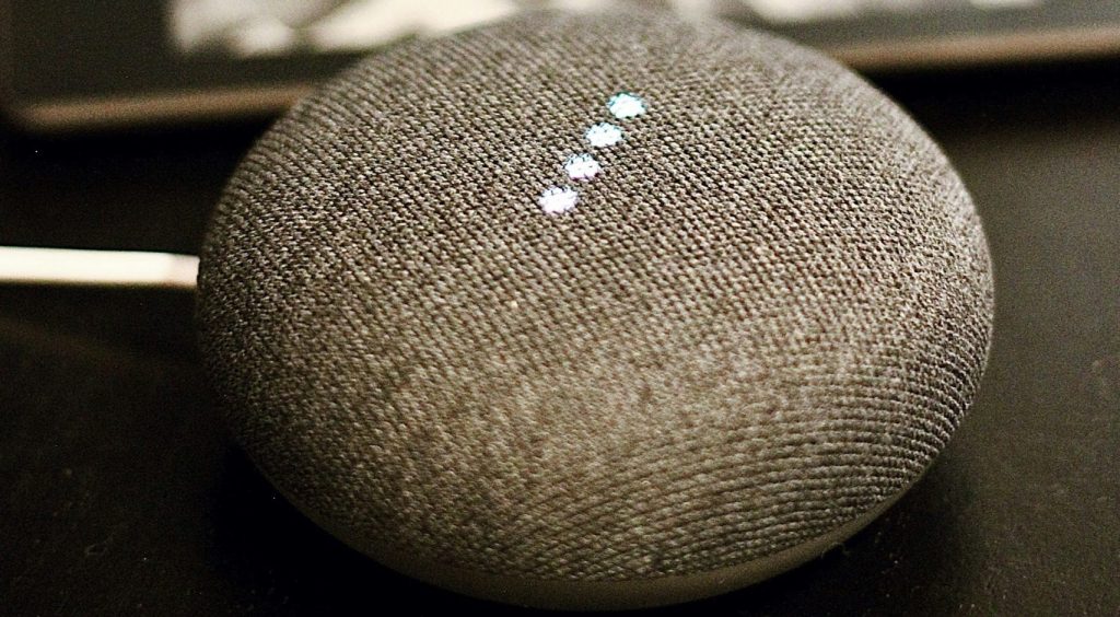 AI assistant speaker next to phone