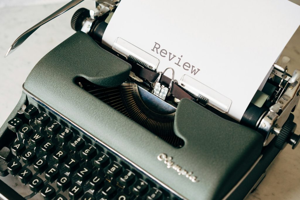 a typewriter with a page that reads "review"