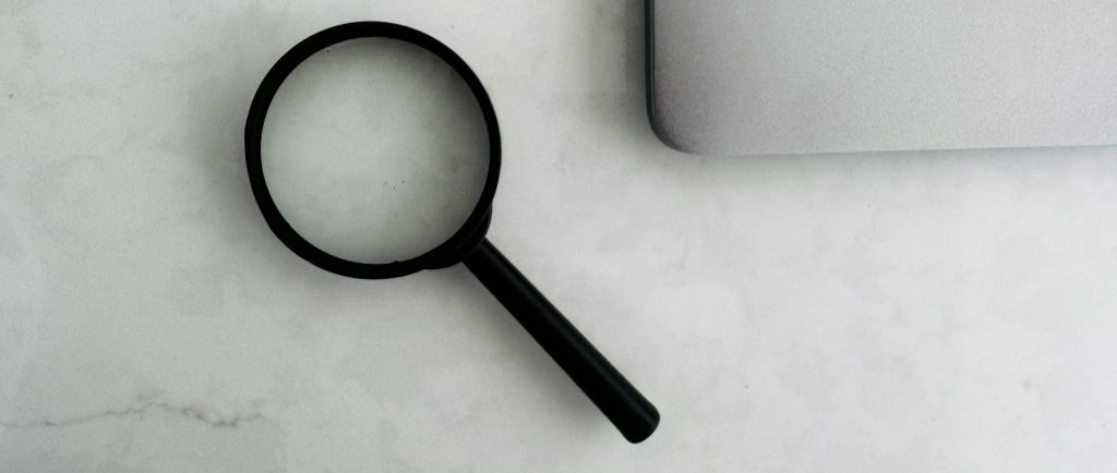 a magnifying glass next to a computer