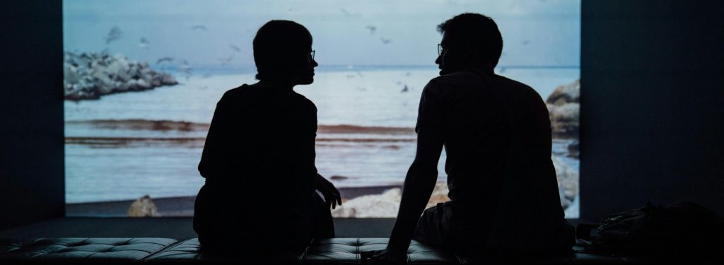 two people in silhouette chatting